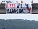 Proposal sign hanging from a bridge.