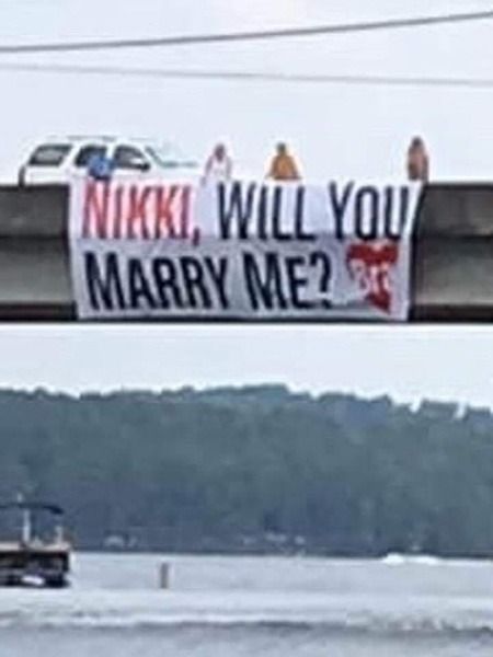 Proposal sign hanging from a bridge.