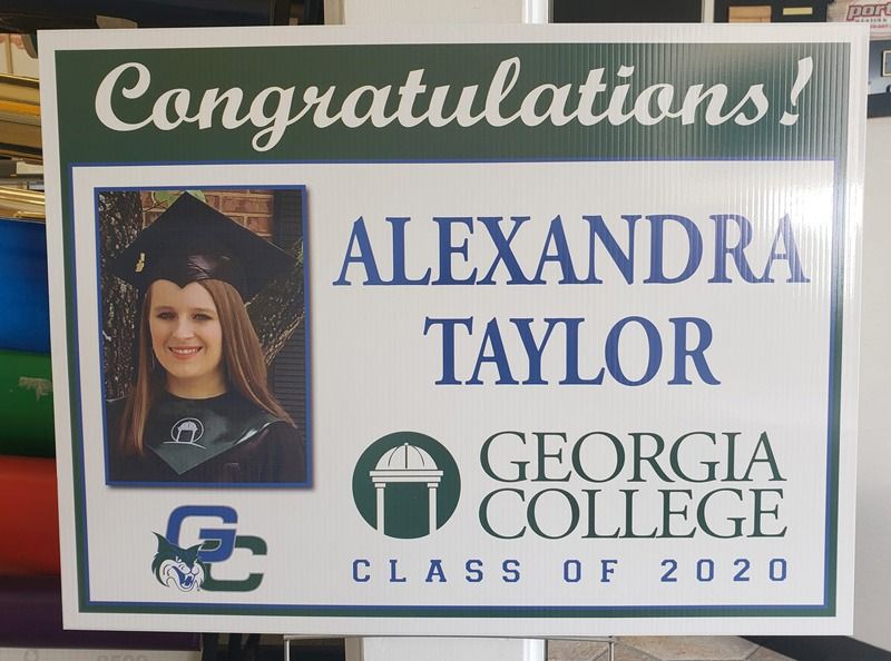 Graduation sign in green lettering.